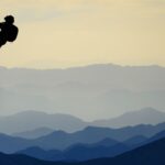 Two climbers climbing up a mountain side